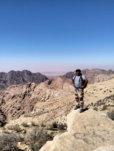 a man standing on a rock in the desert at family home Lodge in Dana