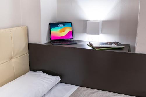a laptop computer sitting on a desk next to a bed at Hotel Demo' in Milan