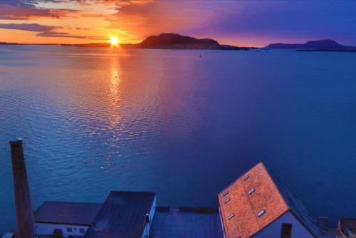 a sunset over a large body of water at Private room in central homestay apartment with sea view in Ålesund