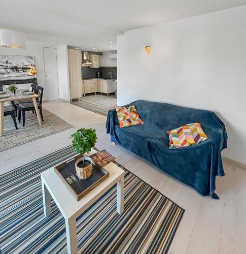 un salon avec un canapé bleu et une table dans l'établissement Séjour Lumineux et Cosy au pied du Cher, à Véretz