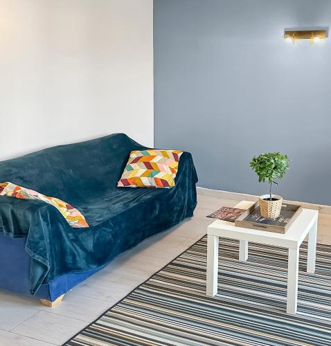 un salon avec un canapé bleu et une table dans l'établissement Séjour Lumineux et Cosy au pied du Cher, à Véretz