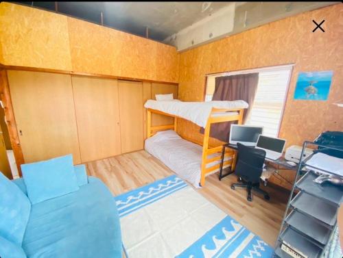 a small room with a bunk bed and a desk at ちゅらIshigaki ユーグレナモールまで徒歩1分 in Ishigaki Island