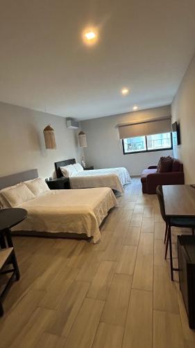 a bedroom with two beds and a living room at Suites Athos4 in Cancún