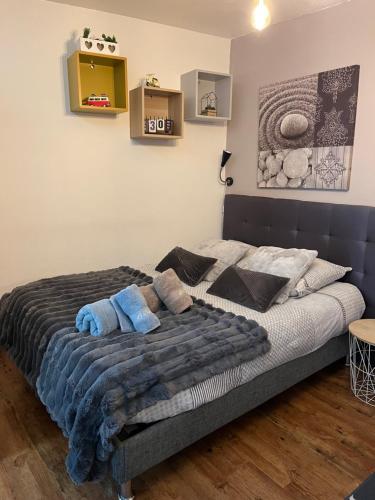 une chambre avec un lit avec des serviettes bleues dessus dans l'établissement Studio aux pieds des montagnes, à Bourg-Saint-Maurice