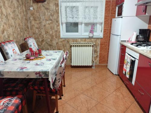a kitchen with a table and a white refrigerator at Zeleni raj in Hreljin Ogulinski