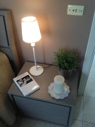 a table with a lamp and a book on a table at Attico Da Rosa con vista spettacolare a 360 gradi in Caltagirone