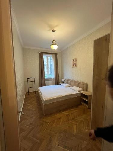 a bedroom with a bed and a wooden floor at vake in Tbilisi City