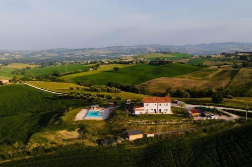 an aerial view of a house in a green field at CASAL DEL SOLE - L'Ulivo in Montefelcino
