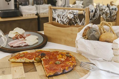 a slice of pizza on a cutting board on a table at La Dimora Di Metello in Matera