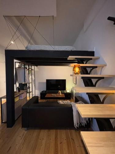 - un salon avec un canapé et une mezzanine dans l'établissement Studio cosy au cœur de ville, mezzanine -203-, à Saint-Étienne