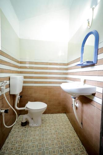 a bathroom with a toilet and a sink at Sherin Cottage in Varkala