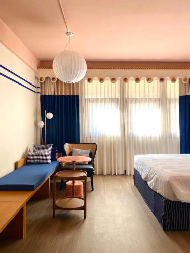 a hotel room with a bed and a couch and a table at Blu Dock Restel Bangkok in Bangkok