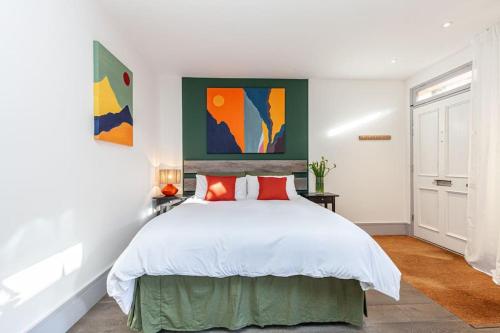 a bedroom with a large white bed with red pillows at Oxford Central Studio 1 in Oxford