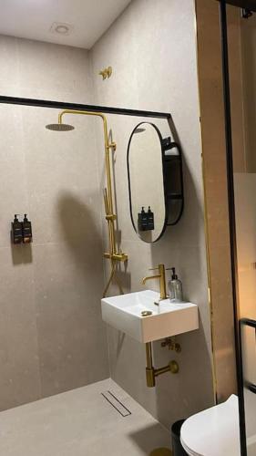 a bathroom with a sink and a shower with a mirror at Beautiful Rooms Nº3 in Camas
