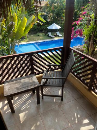 a balcony with a bench and a swimming pool at Triplex vista mar no Pipa Beleza in Pipa