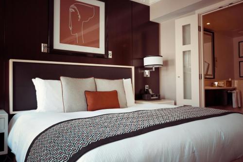 a bedroom with a large bed with a red pillow at Palm Square in Chimoio