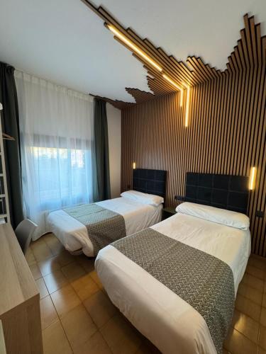 a hotel room with two beds and a window at Hotel Casado in Pas de la Casa