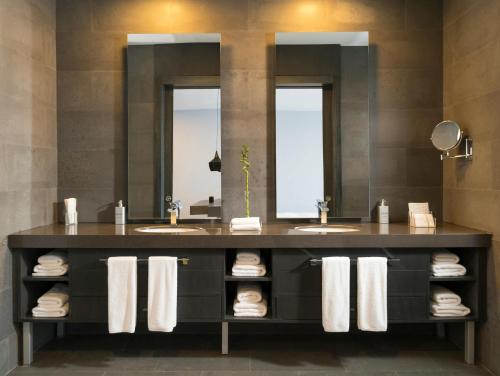 a bathroom with two sinks and two mirrors at Palm Square in Chimoio