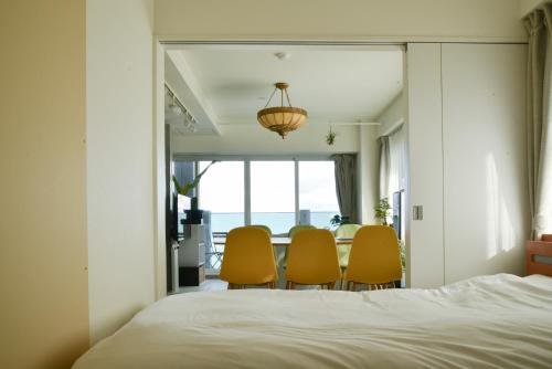 a bedroom with chairs and a table with a window at O2 capsule house OTARU in Otaru