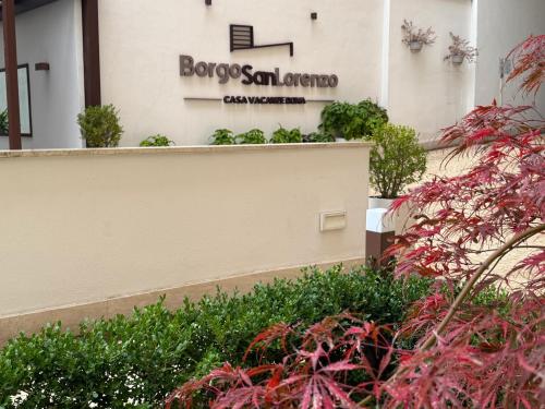 a sign on the side of a building with plants at Borgo San Lorenzo Roma in Rome