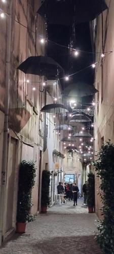 an alley with umbrellas and people walking down it at night at Civico 55b in Bassano del Grappa