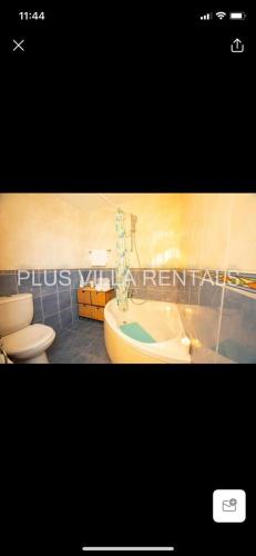 a bathroom with a tub and a toilet and a sink at Villa 4 in Ayia Thekla in Ayia Napa