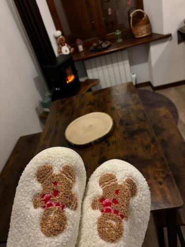 a pair of feet with teddy bear socks on a table at Studio douillet esprit chalet in Sainte-Croix-aux-Mines