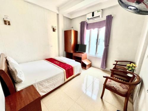a bedroom with a bed and a tv and a chair at Huy Hoang Airport in Hanoi