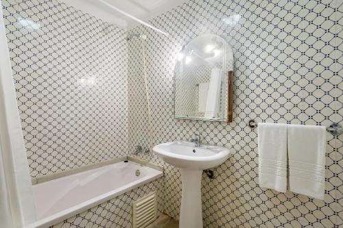 La salle de bains blanche est pourvue d'un lavabo, d'une baignoire et d'un lavabo. dans l'établissement Paula Bela by Garvetur, à Quarteira