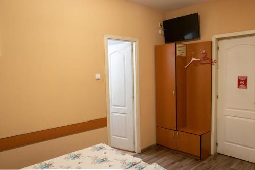 a room with a bed and a refrigerator at Hotel Tranzit in Odorheiu Secuiesc