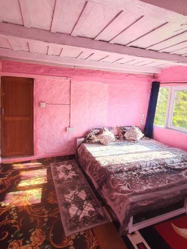 a pink room with a bed and a window at Mudhouse Cottage in Apple Orchard - Sainj Valley in Sainj