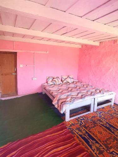 a bedroom with two beds in a pink room at Mudhouse Cottage in Apple Orchard - Sainj Valley in Sainj