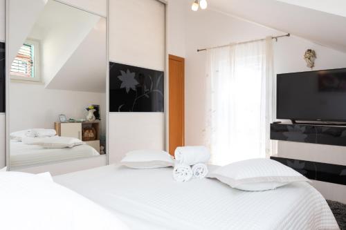 a bedroom with a white bed and a mirror at Apartment Dome in Split