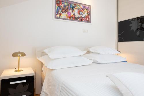 a bedroom with a white bed with white pillows at Apartment Dome in Split