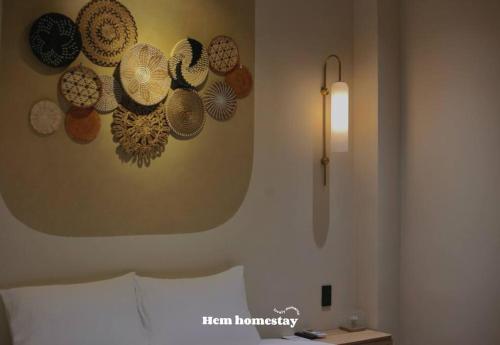 a bedroom with a wall with hats on the wall at Hẹ Stay in Hue