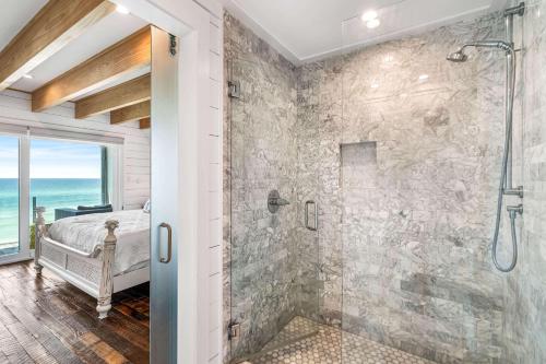 a bathroom with a walk in shower and a glass door at The Good Life in Inlet Beach