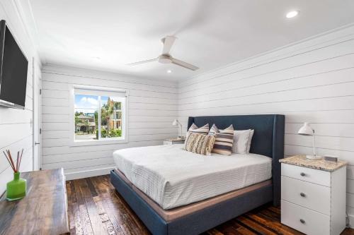 a white bedroom with a bed and a window at The Good Life in Inlet Beach