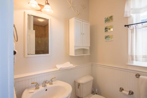 a white bathroom with a sink and a toilet at Beach Music in Rosemary Beach
