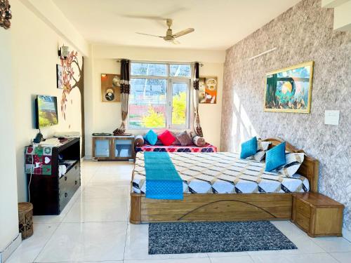 a bedroom with a bed with blue and red pillows at The Auriga 3BHK Fully Entair Villa with Bonfire in kasauli I Pvt Stay I Open Air Terrace I Kitchen Livingroom I Lawn Bonfire I Gaming Zone in Kasauli
