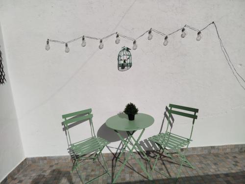 a table and two chairs and a table with a lamp at Casa dos Josés in Elvas
