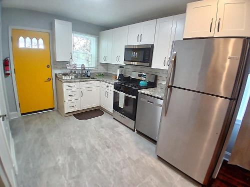 a kitchen with white cabinets and a stainless steel refrigerator at Luxury & Restful Private Room in DC in Washington