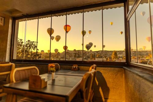 a restaurant with a view of hot air balloons in the sky at Cappadocia Divin House in Goreme