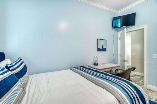a bedroom with a bed with a tv on the wall at Sandy's Seacrest in Inlet Beach