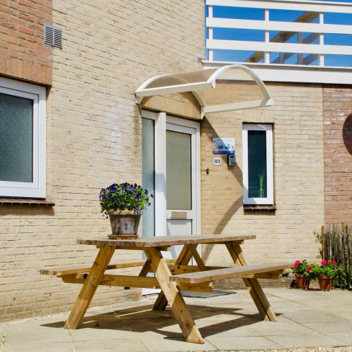 a wooden picnic table with a potted plant on it at Mosselbank 93 - Noordzeepark Ouddorp, with private front and back garden near the beach - not for companies in Ouddorp