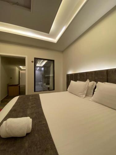 a bedroom with a large bed with white sheets and pillows at Golden New Tulip Abha in Abha