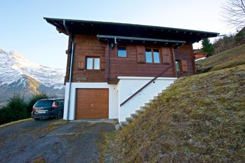 a house on a hill with a car parked in front at L'observatoire des Alpes, les Crosets in Val-d'Illiez
