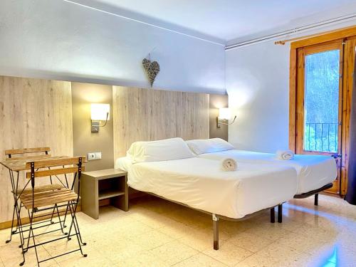 A bed or beds in a room at Hostal La Cabanya