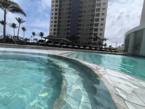 a swimming pool with blue water in front of buildings at Salinas Exclusive Resort in Salinópolis