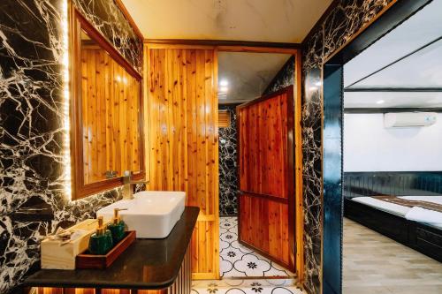 un baño con lavabo y espejo en ADUTA CRUISE, en Cat Ba