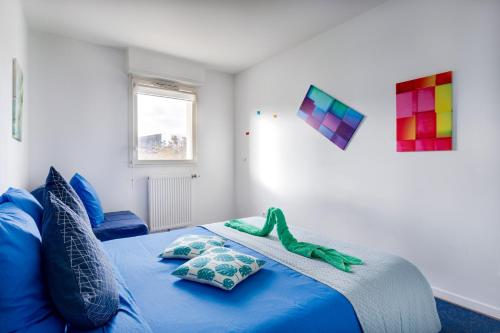 - une chambre avec un lit bleu et des oreillers dans l'établissement Lego Party Time - Disney à 2 pas, à Chanteloup-en-Brie